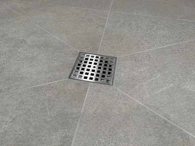 Square stainless steel shower drain in stone-look tile